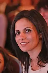 Yifat Bitton ist im Porträt zu sehen. Sie hat langes braunes Haar und lächelt in die Kamera.
