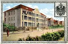 farbige Ansichtskarte mit einem Gebäude und dem Reichsadler rechts oben
