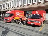 Foto zweiter roter Klein-LKW und mehrerer Motorräder