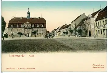 Liebenwerdaer Markt um 1903 auf einer zeitgenössischen Ansichtskarte. Das Hotel „Zum Weißen Roß“ ist rechts im Bild zu sehen.