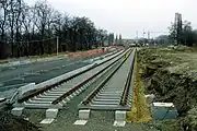 Zwi­ckau­er Stra­ße (Leip­zig), tief­lie­gen­des Ra­sen­gleis im Bau. Die Fahr­bahn­bal­ken lie­gen auf Stütz­punk­ten auf und bil­den pro Gleis zwei ne­ben­ein­an­der­lie­gen­de un­ter­ir­di­sche Brü­cken. Die Gleis­lage wird durch elas­ti­sche Bei­la­gen zwi­schen Fahr­bahn­bal­ken und Schwel­len re­gu­liert, re­gel­mä­ßi­ges Stop­fen ist nicht er­for­der­lich und auch nicht mög­lich.
