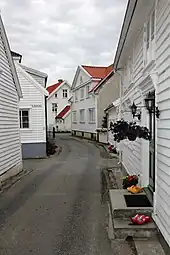 Foto einer engen Gasse, die von weißen Holzhäusern gesäumt ist