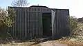 Offen stehender Nuklearwaffenbunker mit Drahtgeflechtschutz