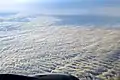 Altocumulus undulatus mit zwei Wellensystemen vom Flugzeug aus gesehen.