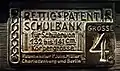 Blechschild Größe 4: „Rettig's Patent Schulbank / für Schüler von 132 bis 141 cm Körpergröße / Patentinhaber P. Johs. Müller / Charlottenburg und Berlin“