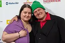 Portrait: Links Iris, die Ehefrau von Manni Ludolf, rechts Manni Ludolf mit einer grünen Pudelmütze