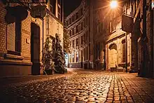 Nachtaufnahme einer Gasse mit Kopfsteinpflaster. Links eine Gaststätte mit Schild "Anno Pief", rechts in einer leichten Linkskurve mehrere alte Mehrfamilienhäuser
