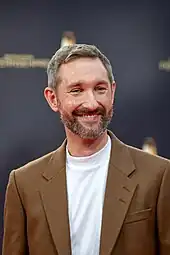 Daniel Boschmann in braunem Sakko und weißem Pullover