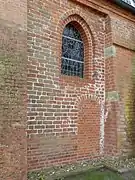 Altes Mauerwerk in der Nord­wand des Chors, Korb­bogen der Priester­pforte wohl etwas neuer, Innen­stufe des Fenster­gewändes und unterste 10 Stein­reihen ersetzt.