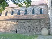 Langhaus von Süden: Portal und Obergaden spitzbogig mit Quader­mauer­werk, Kreuz­gang­an­schluss rund­bogig mit Feldsteinmauerwerk