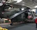 Ein BHS Sea King im Hangar. Unter dem Hinterrad ist die Verfahranlage sichtbar, die Rotorblätter sind gefaltet.