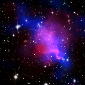 Falschfarbenbild des Galaxienhaufens. (Orientierung: Norden oben, Osten links.) In Blau ist die Verteilung der dunklen Materie gezeigt, während die roten Bereiche die Regionen erhöhter baryonischer Dichte kennzeichnen.