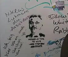 „Müller-Esterl, du hast mein Studium zerstört“ – Stencil in einem Aufzug des AfE-Turms, das Müller-Esterls Rolle als Universitätspräsident in Form einer Anspielung auf einen Songtitel von Tocotronic kritisiert. Foto von 2014.