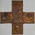 Über dem Altar hängt ein bronzenes Altarkreuz mit fünf unterschiedlichen biblischen Motiven der Künstlerin Moni Jahn.
