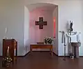 Der Altarraum der Kirche mit dem Altar in der Mitte, gesäumt von Taufbecken und Ambo.