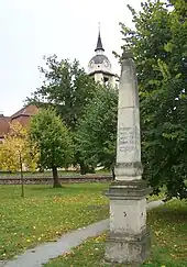Distanzsäule auf dem Markt, im Bildhintergrund die evangelische Kirche