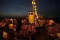 Partygäste auf dem Oberdeck mit abendlicher Aussicht über Sendling