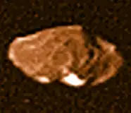 Farbfoto, gemacht von Voyager&nbsp;1,1979. Pan ist am oberen rechten Rand zu erkennen, wie auch Gaea am unteren zu sehen ist (helle Flecken).