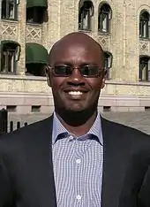 Andrew Mwenda, ein Mann im Anzug, lächelt