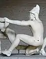 Trojanischer Bogenschütze (der sogenannte Paris), Westgiebelgruppe des Aphaiatempels, ca. 505 bis 500 v.&nbsp;C. Die Ohrenlaschen sind hinter dem Kopf verschlungen.