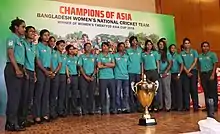Cricket Team im Halbkreis hinter dem Pokal des Asia Cups