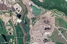 Links: Satellitenaufnahme des nördlichen Teils der „Millennium Mine“ der Suncor Energy und angeschlossene Infrastruktur. Der große Fluss in der linken Bildhälfte ist der Athabasca River. Rechts: Teil des Tagebaus sowie Schwefelhalden und Absetzbecken („Syncrude tailings pond“) der Aufbereitungsanlage „Mildred Lake“ von Syncrude.