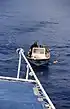 Mönch mit Motorboot und Mobiltelefon holt eine Proviant-Lieferung von einem Ausflugsschiff (2002)