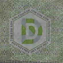 Das Durchsichtsregister auf einer 5-DM-Banknote BBk&nbsp;III (hier im Gegenlicht) ist von Mikroschrift umgeben.