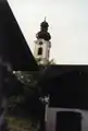 Kreuzkirche hinter alpenländischen Häusern