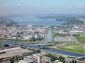 Luftbild des Zusammenflusses von Rio Guarapiranga und Rio Grande zum Rio Pinheiros mit dem Guarapiranga-Stausee im Hintergrund.