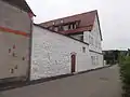 Ansicht vom ehemaligen Stadtgraben aus mit einem Teil der renovierten Stadtmauer (weiß)