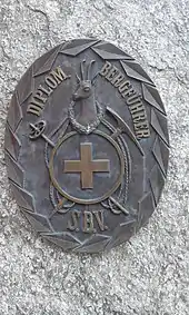 Das Originalabzeichen in Bronze (70 × 55&nbsp;cm) der diplomierten Bergführer des Schweizer Bergführerverbands (S.B.V.) auf dem Bergführerdenkmal  in St.&nbsp;Niklaus Dorf