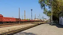 Ein Bahnsteig und im Hintergrund ein Güterzug