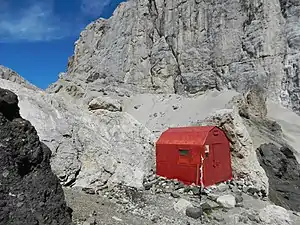 Die Biwakhütte Marco Dal Bianco (2015) im Hintergrund der Passo Ombretta, die Südwand der Marmolata und am linken Bildrand die Forcella Marmolada (2885 m)