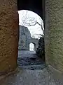Blick durch ein Fenster des Palas in die Burg auf das Eingangstor in der Westwand