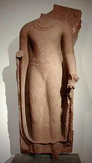 Buddha in einer Uttarâsangâ-Robe, Frühphase des Gupta-Reiches 6. Jhr., Mathura-Schule, roter Sandstein. Indien.
