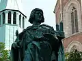 Detail der Figur Heinrichs des Löwen, im Hintergrund die Türme der Katharinenkirche.