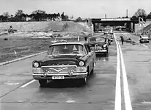 GAZ-13 „Tschaika“ auf dem Ost-Berliner Adlergestell während einer Einweihung, dahinter ein GAZ-12 ZIM (1962)