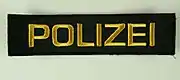 Schriftzug auf den Uniformen der Polizei