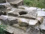 Ausgusstein in der hochmittelalterlichen Ringmauer der Ostseite. Der Schacht öffnete sich vor dem Bau der Zwingeranlage in den Burggraben