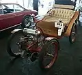 900 Société Parisienne Victoria Combination (CA. 1899). Bis auf die Drehschemellenkung entspricht die Anordnung von Motor, Getriebe und Achse jener des De Dion-Bouton Tricycle. Der gerippte Motorblock ist typisch für die luftgekühlten Ausführungen.