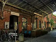 Auf dem Bild zu sehen ist der Eingangs der Cammerspiele Leipzig, eine Tür in einer ehemaligen Fabrikhalle aus roten Ziegeln