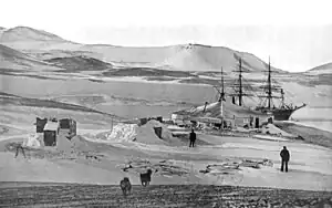 Der Hut Point (Vordergrund) mit der in der Winter Quarters Bay eingefrorenen RRS&nbsp;Discovery