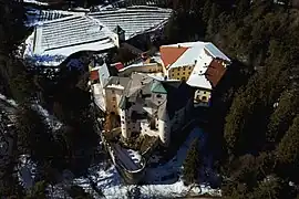 Luftaufnahme mit der Ostseite im Vordergrund; rechts im Hintergrund die Wirtschaftsgebäude