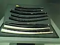 Sammlung von zehn verschiedenen historischen Zinken in gekrümmten und geraden Formen, in hellen und dunklen Materialien, mit metallischen und nichtmetallischen Mundstücken, unverziert und mit Schnitzmuster ausgerüstet; Vitrine im Musikmuseum in der Cité de la musique von Paris