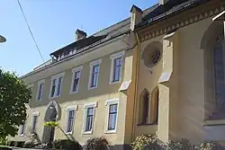 Das Pfarrhaus ist mit der Kirche verbunden und befindet sich auf deren südlicher Seite.