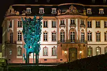 Der Osteiner Hof bei Nacht, davor der beleuchtete Fastnachtsbrunnen