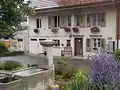 Brunnen und Wohnhaus an der Dorfstrasse in Wäldi
