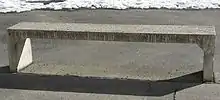 Beton-Sitzbank; die wegen Fertigung „in einem Guss“ bereits höhere Ecksteifigkeit hat; mit kleinen Vouten weiter vergrößert (Querschnittsvergrößerung).
