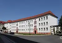 Der leicht geschwungene Gebäudeteil Eckartstraße 25–27 setzt am linken Bildrand an die Straßenrandbebauung Leipziger Straße (Hausnummern 58–61) an. (2012)
